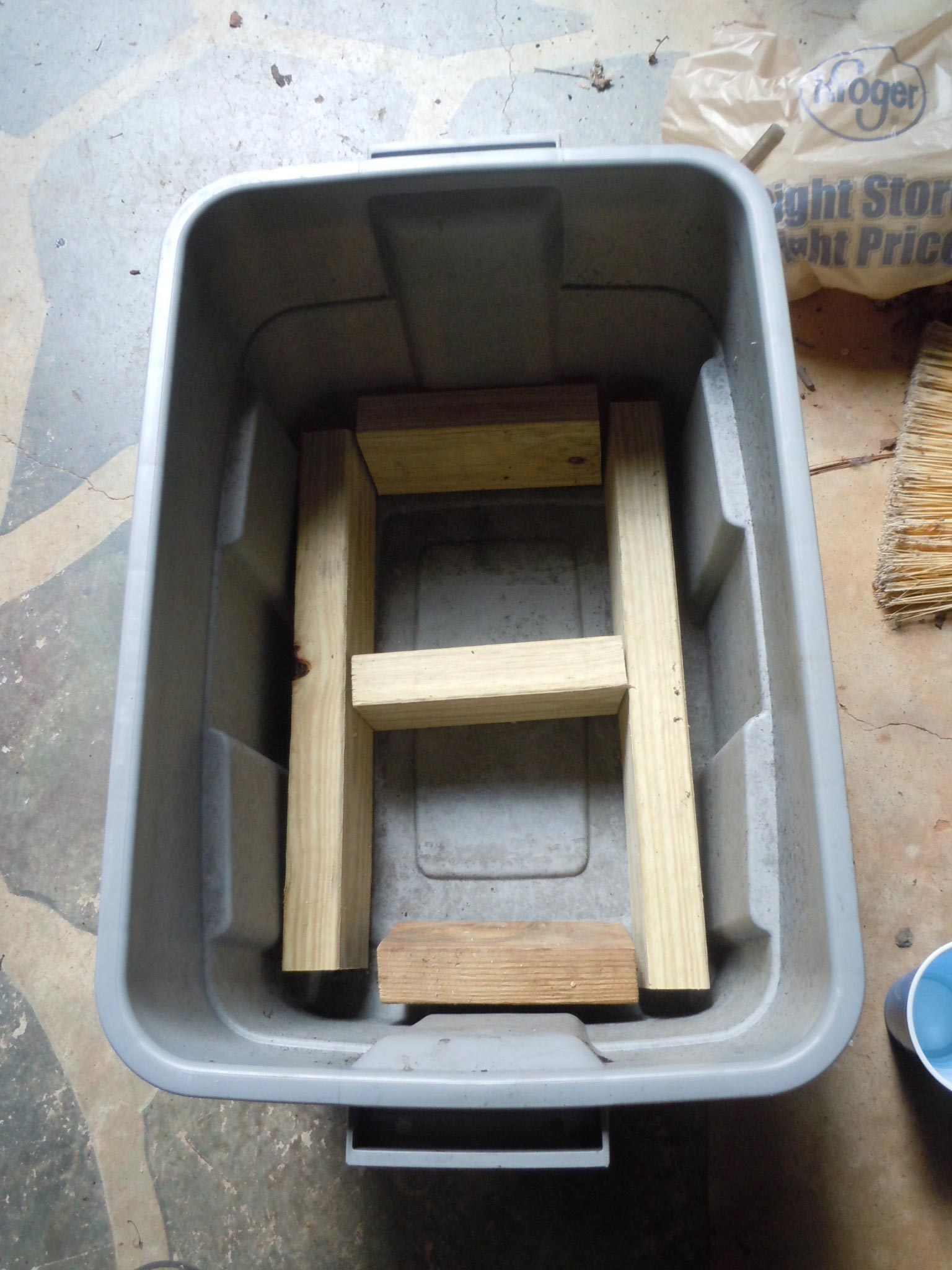 cut pressure treated 2"x4" lumber to fit inside and support the plastic lid